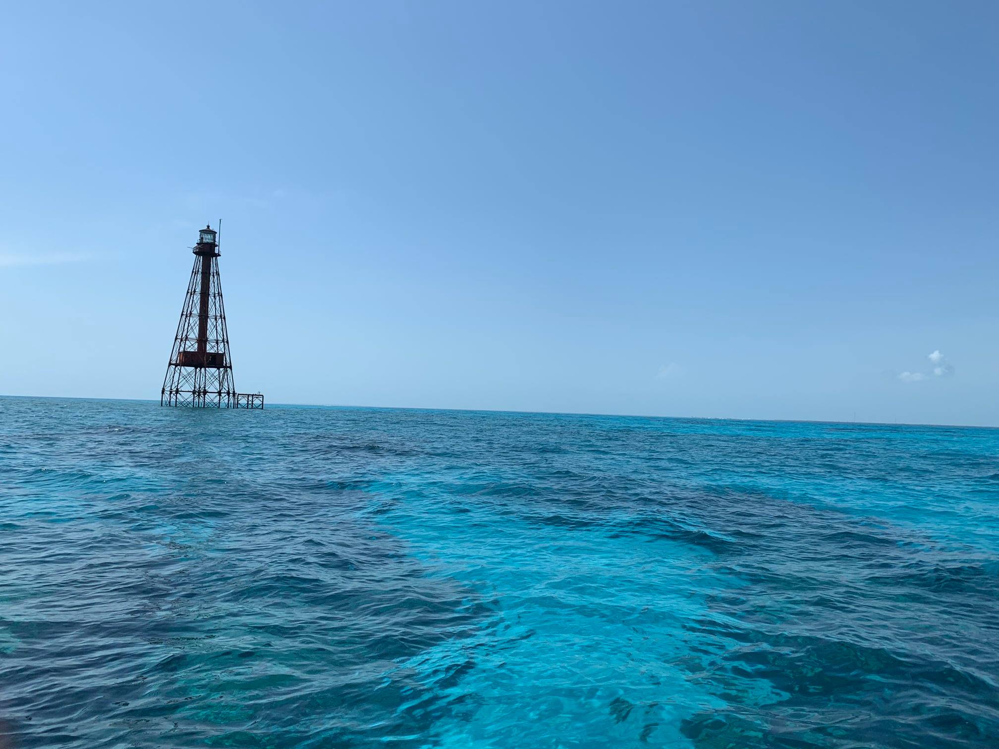 offshore skeletal lighthouse in turquoise ocean