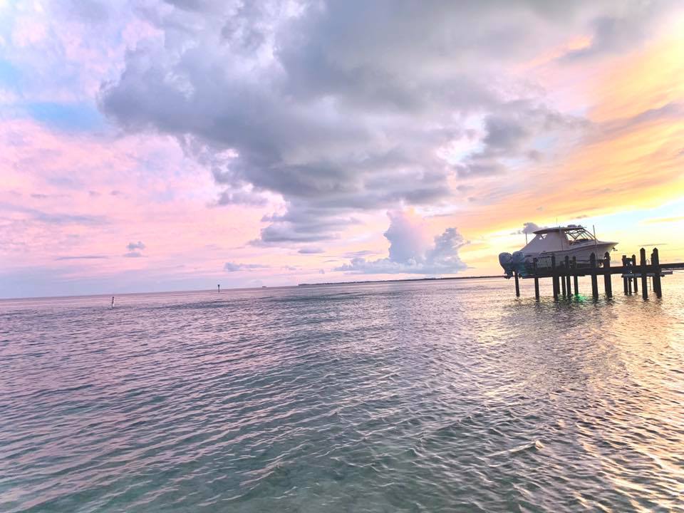 Boat on dock at pastel seaside sunset