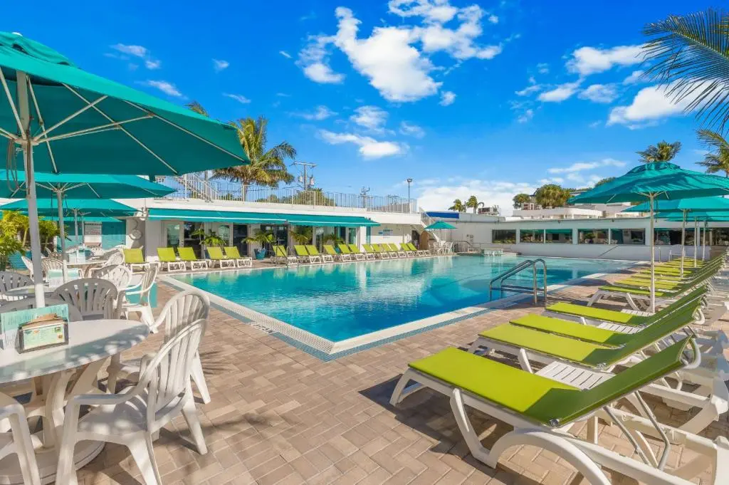 Sunny resort pool with lounge chairs and umbrellas