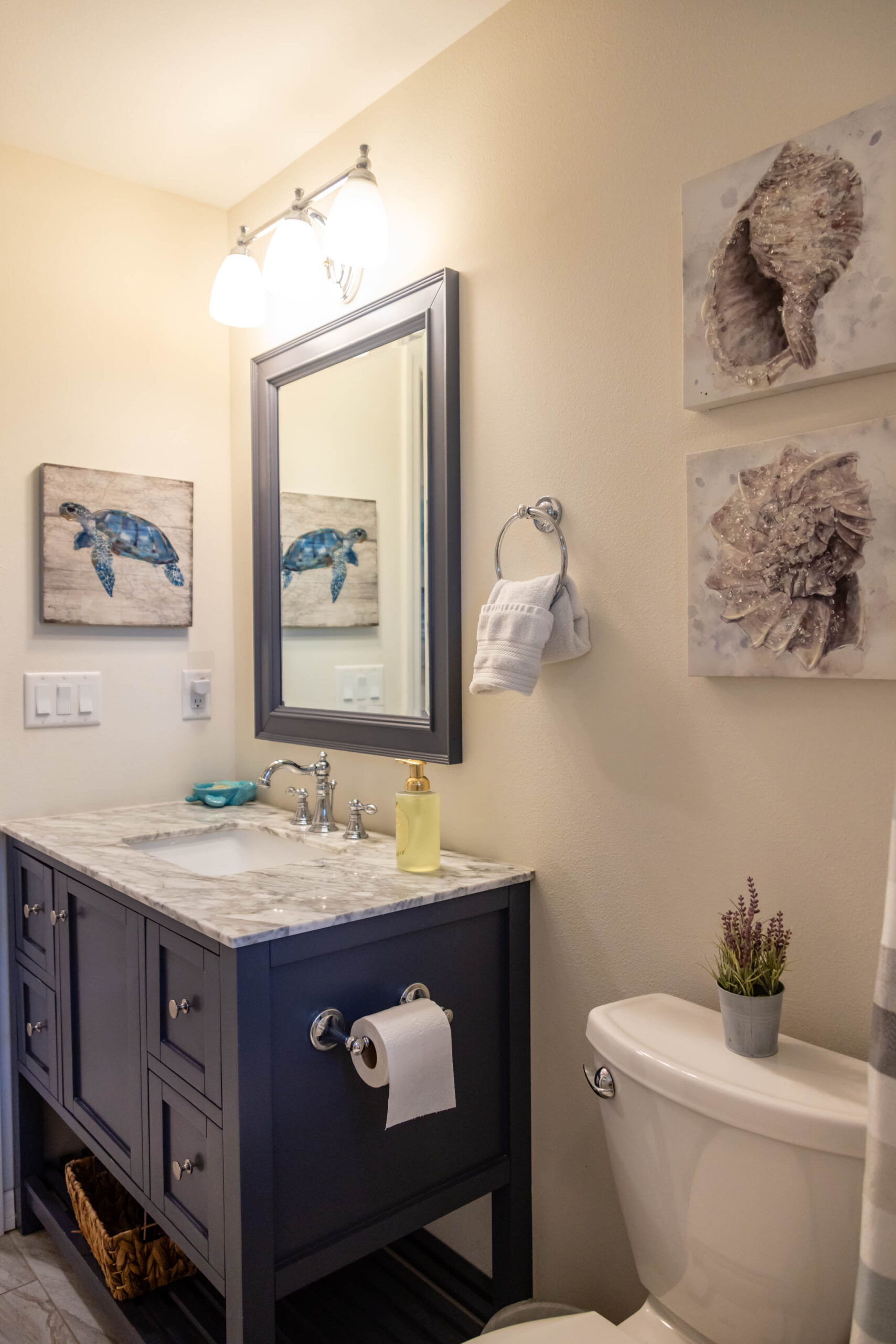 Coastal bathroom with navy vanity and mirror