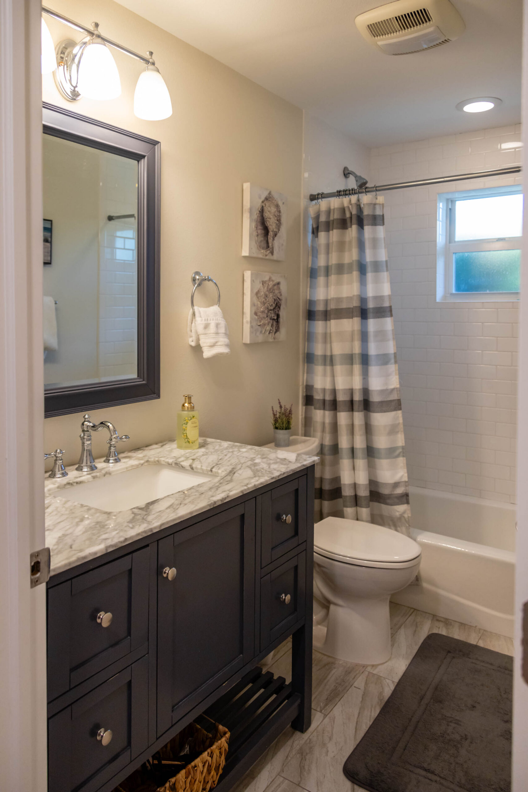 Bathroom with dark vanity and striped shower curtain