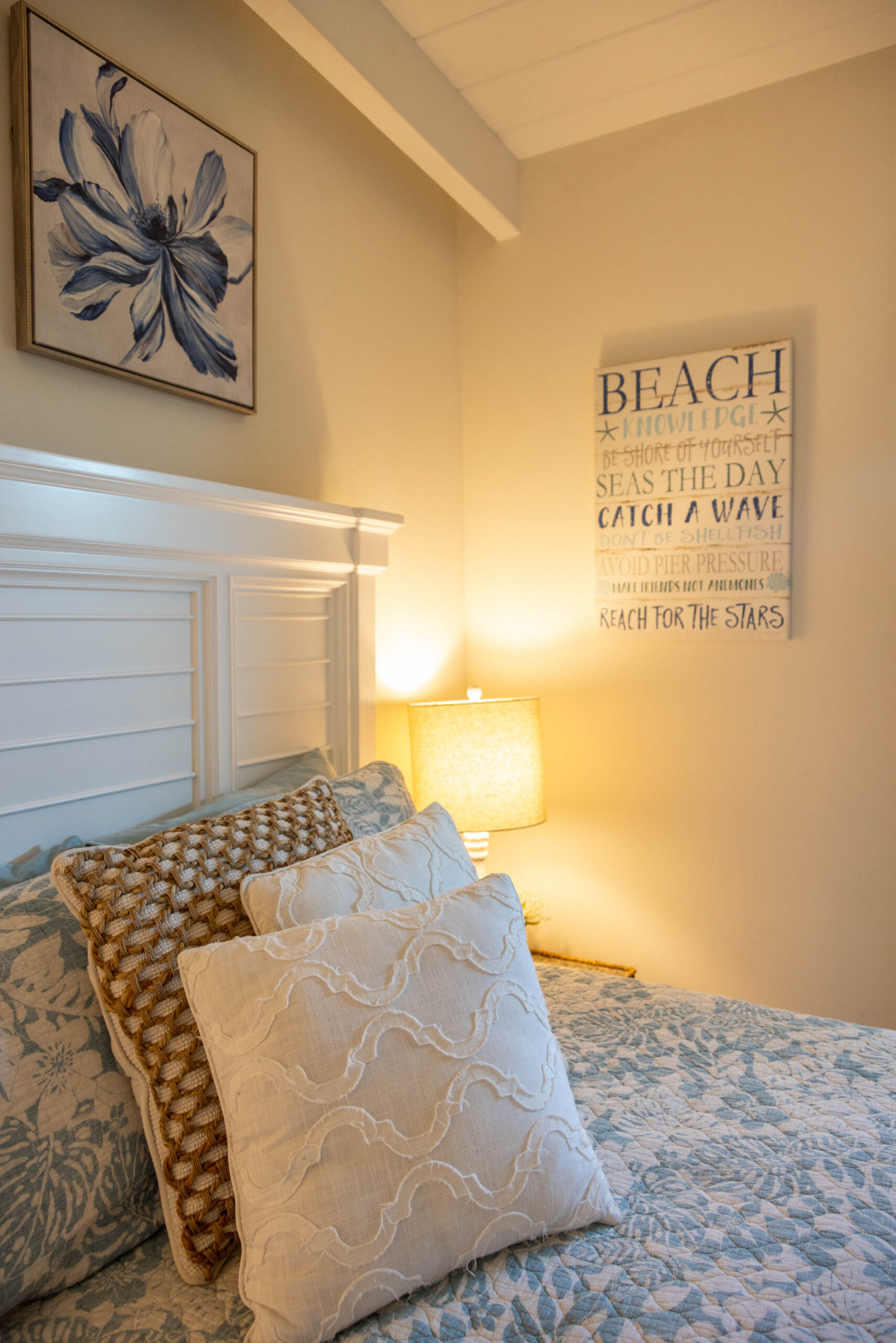 Cozy beach-themed bedroom with pillows and lamp