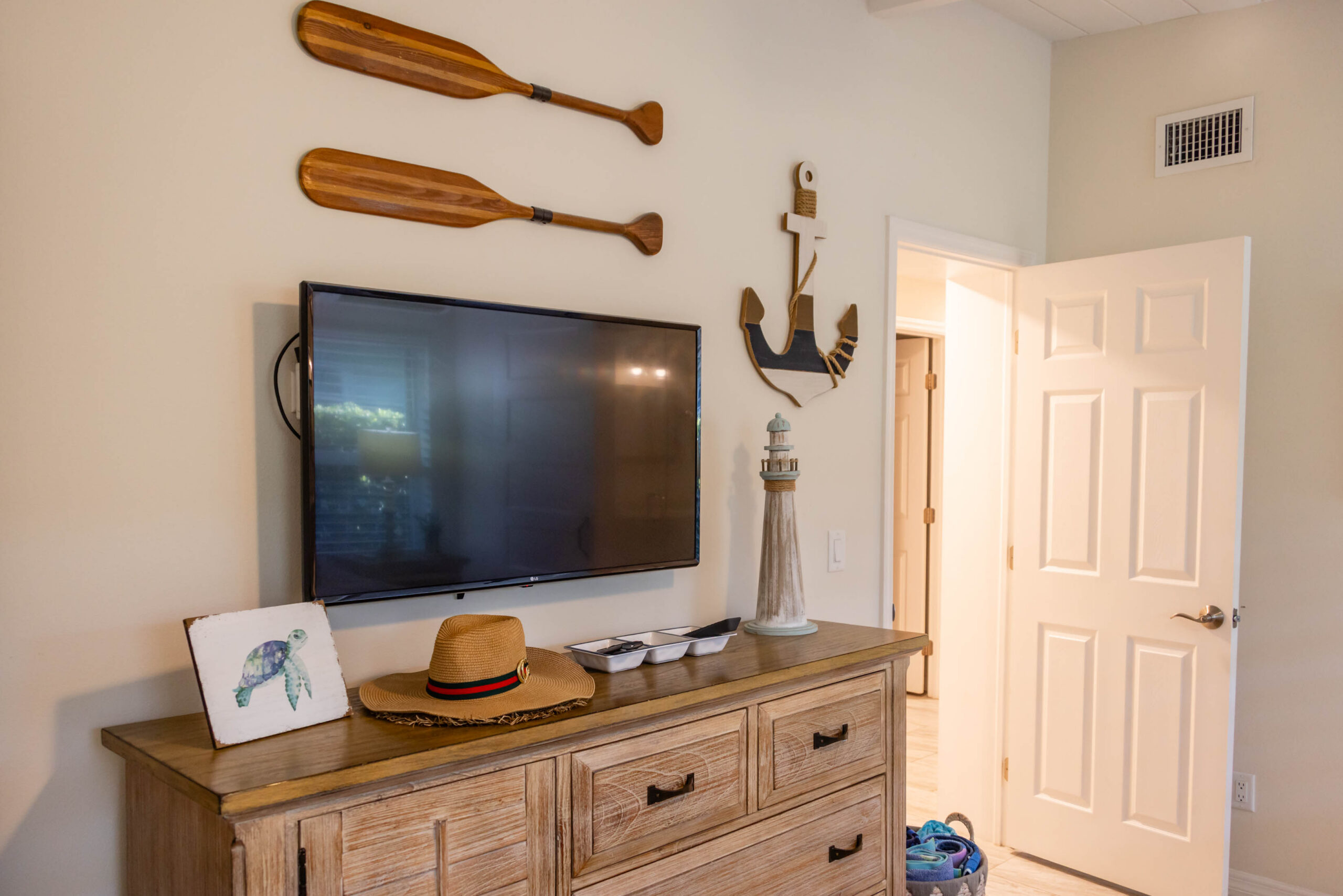 Bedroom dresser with mounted TV and nautical decor