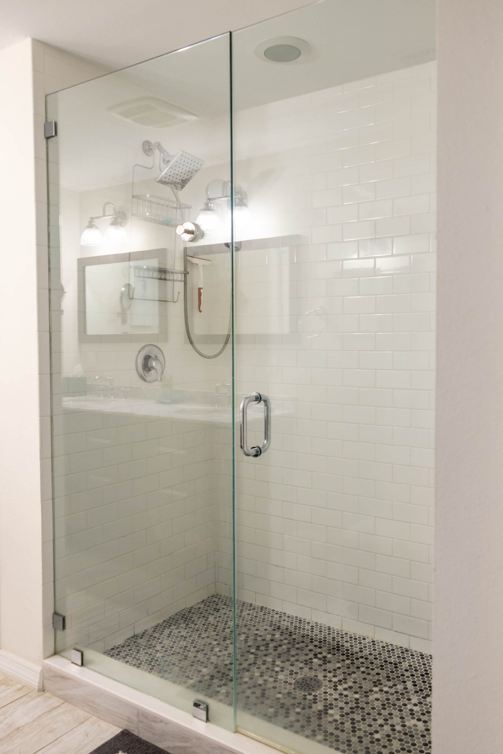 Frameless glass shower with mosaic tile floor