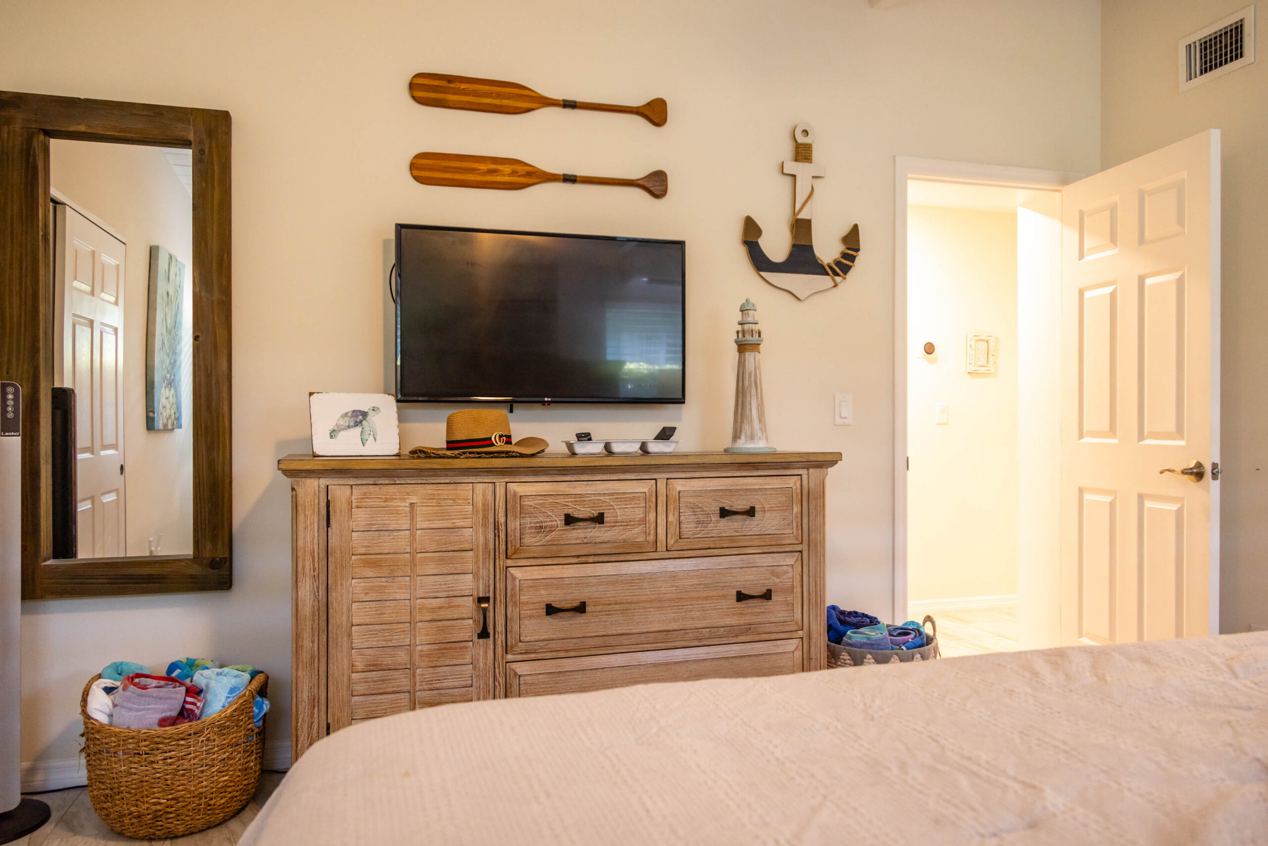 Cozy bedroom with dresser, TV, and nautical decor