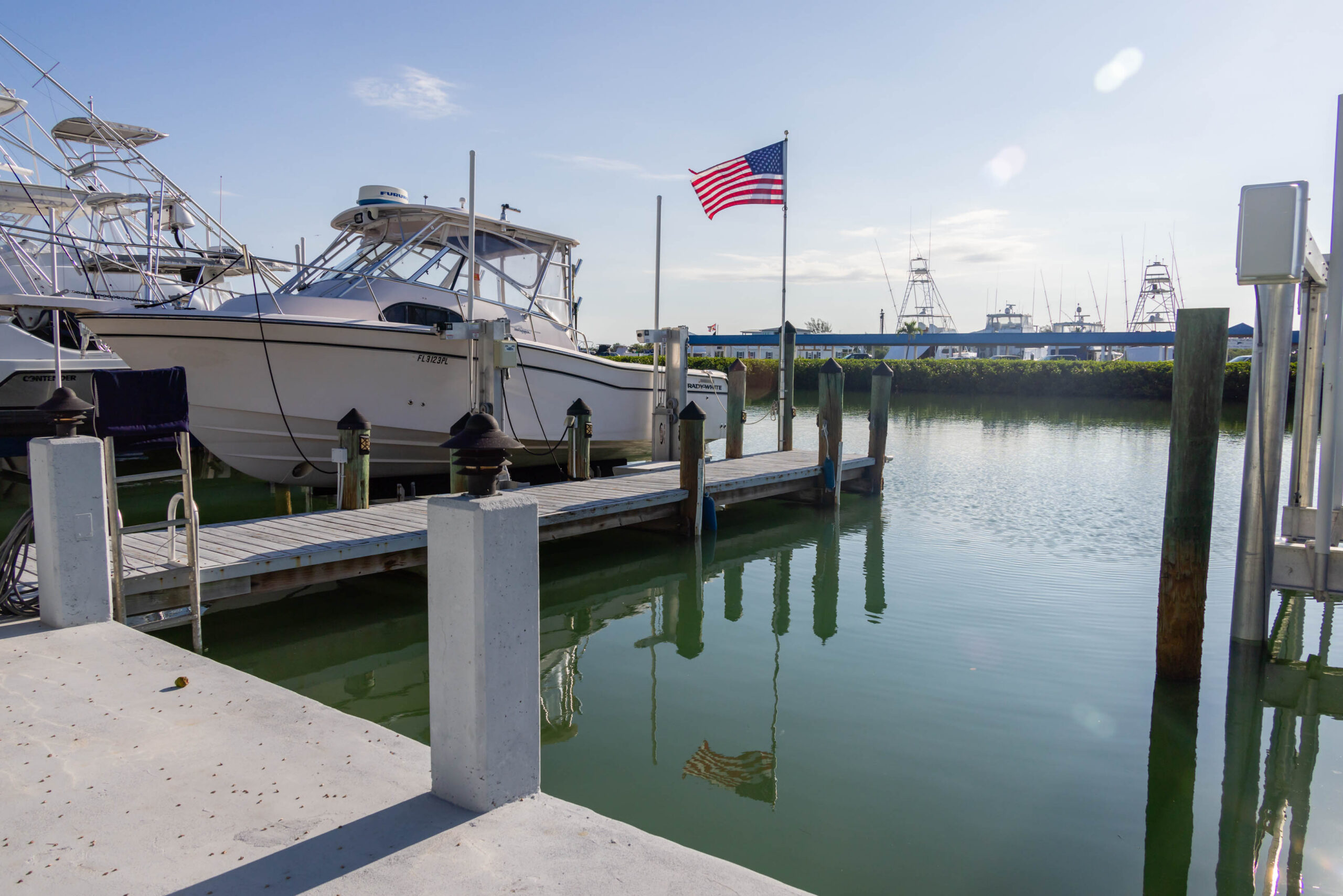 Boats docked at marina with American flag