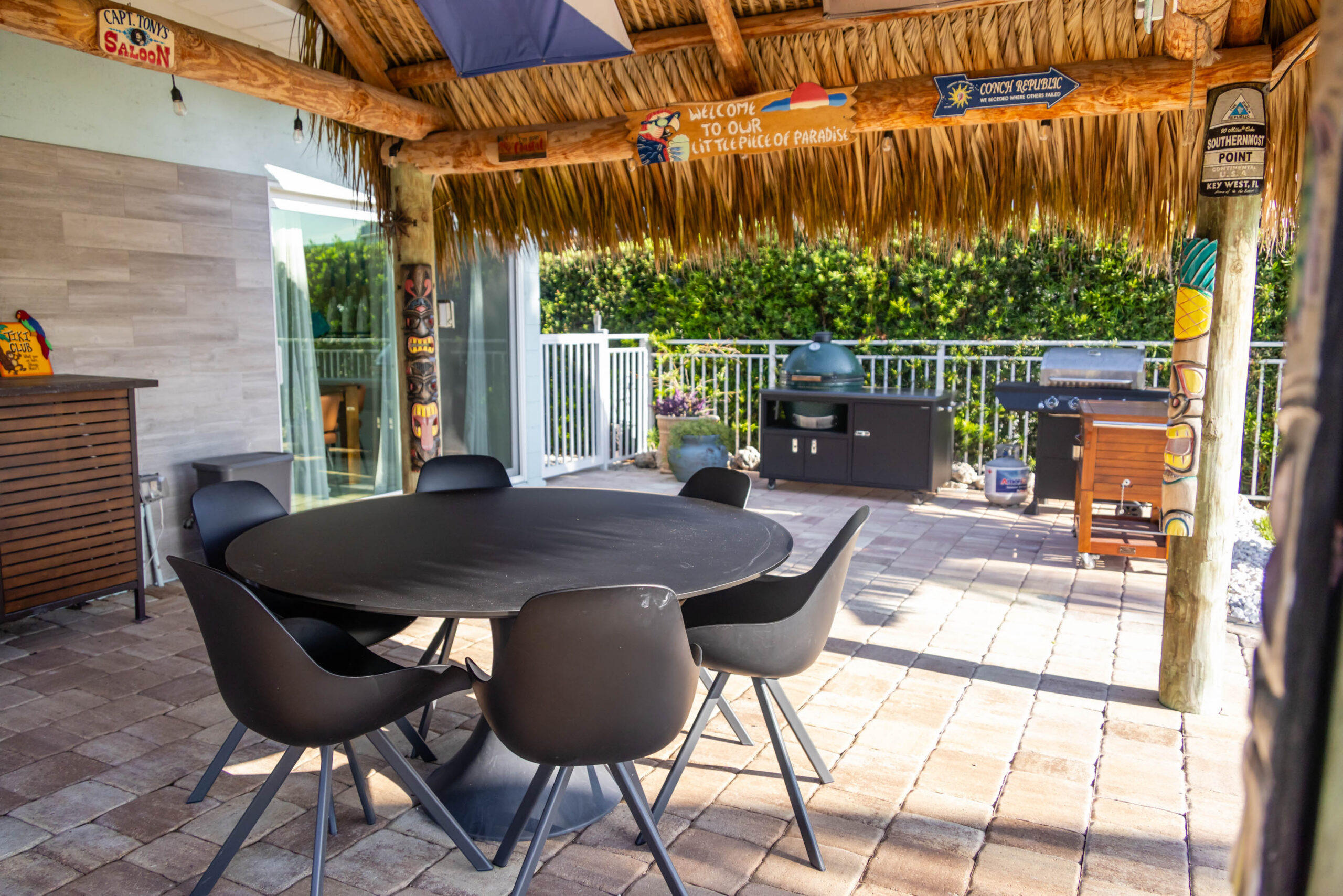 Outdoor tiki patio with round table and grill