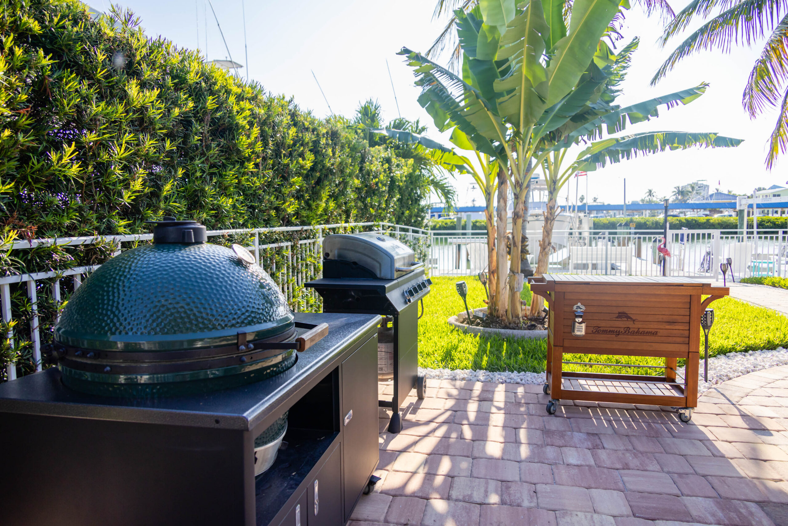 Waterfront patio with grills and tropical plants