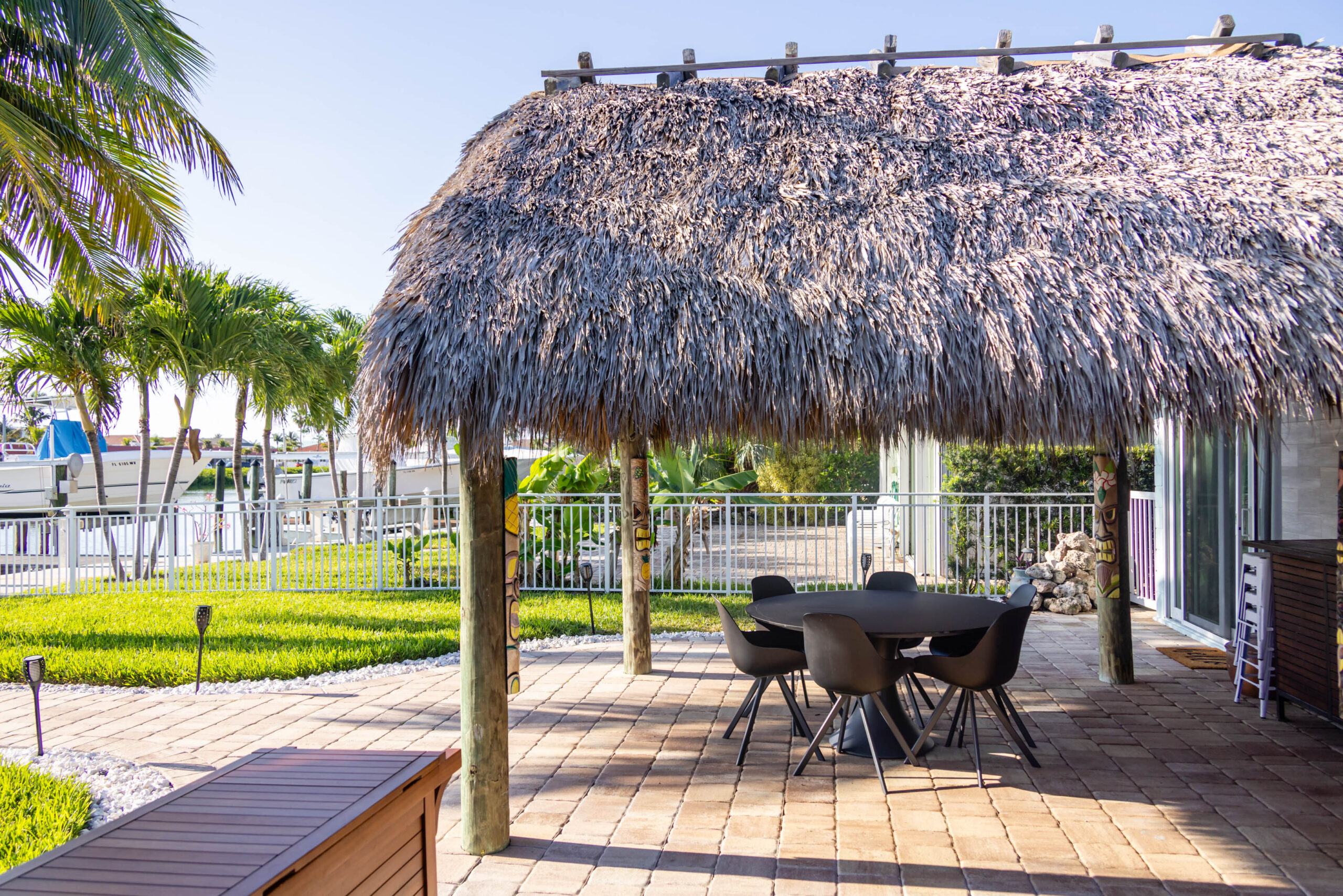 Waterfront tiki hut patio with table and chairs