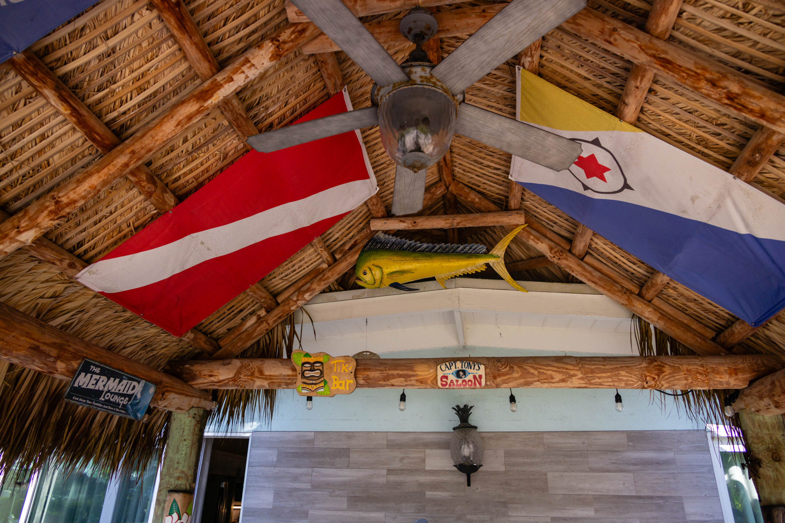 Thatched tiki bar ceiling with flags and fan