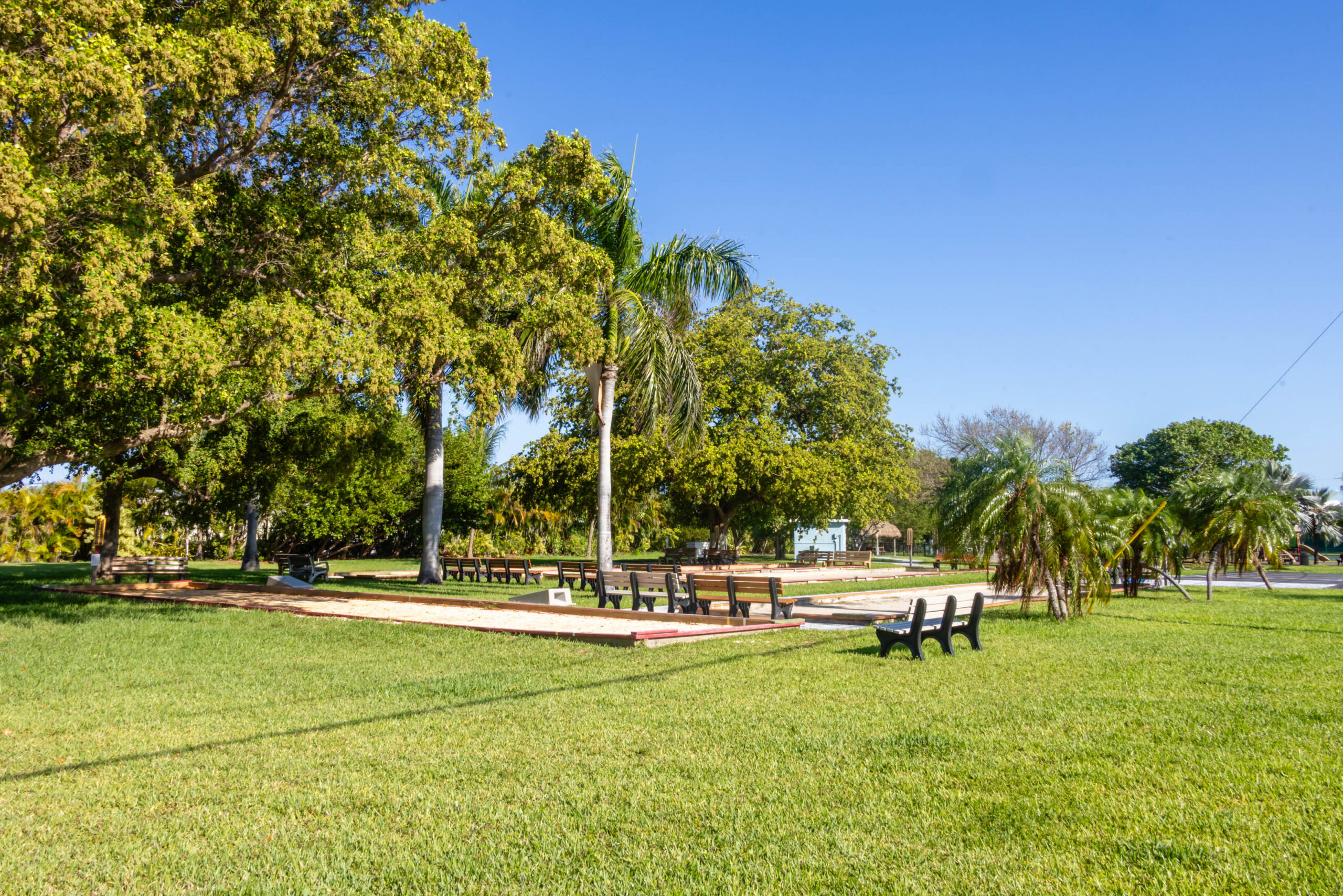 Park lawn with bocce courts and palm trees