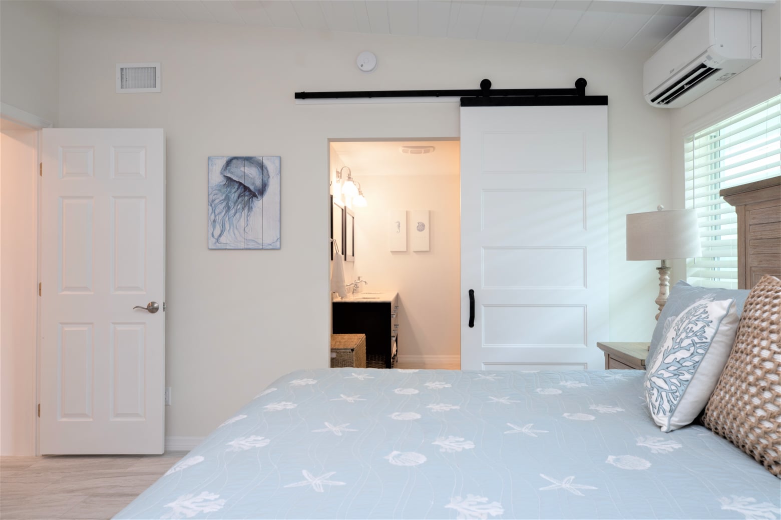 Bedroom with light blue bedding and barn door