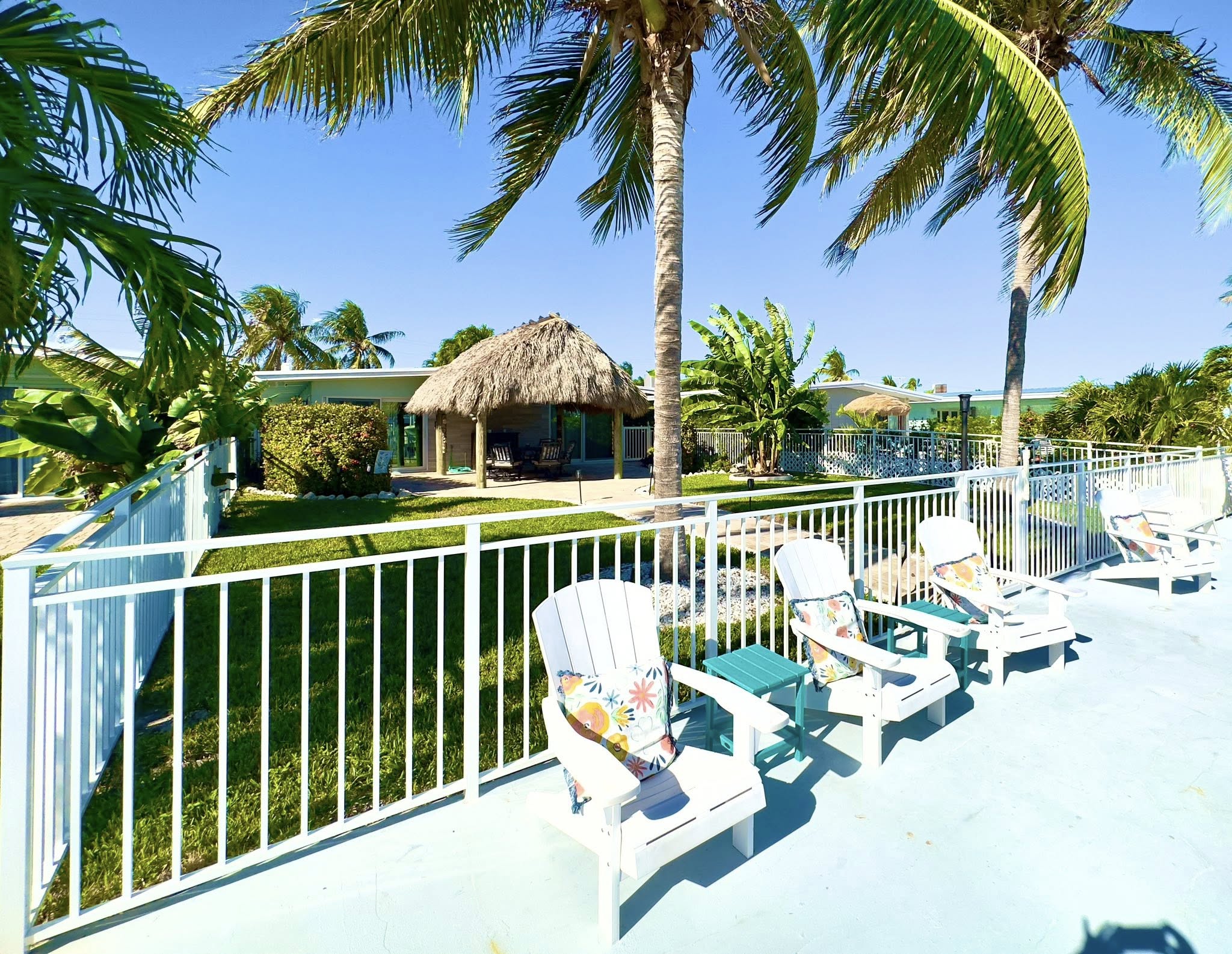 Tropical poolside lounge chairs and tiki hut