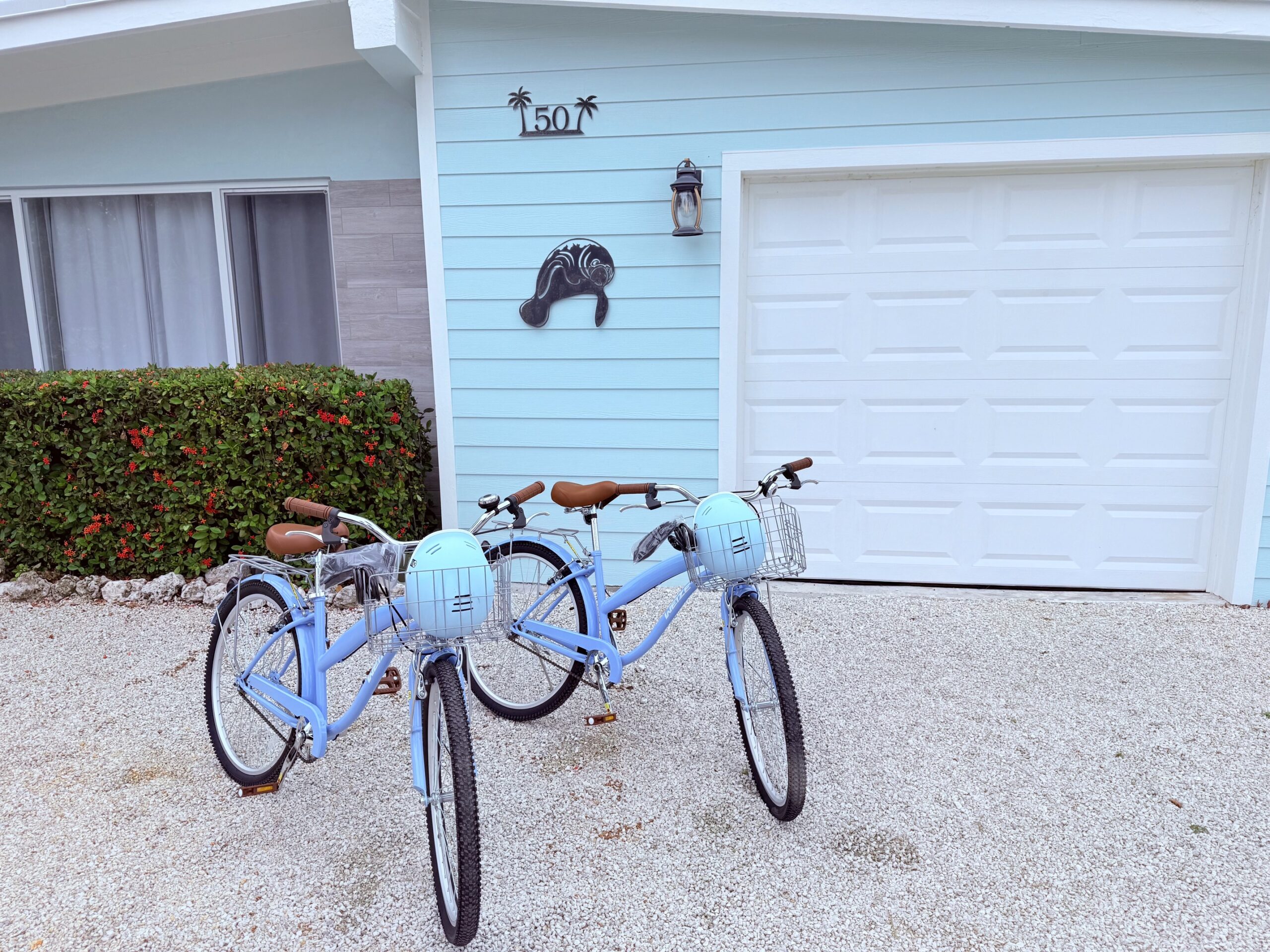 Three blue bicycles parked in front of house