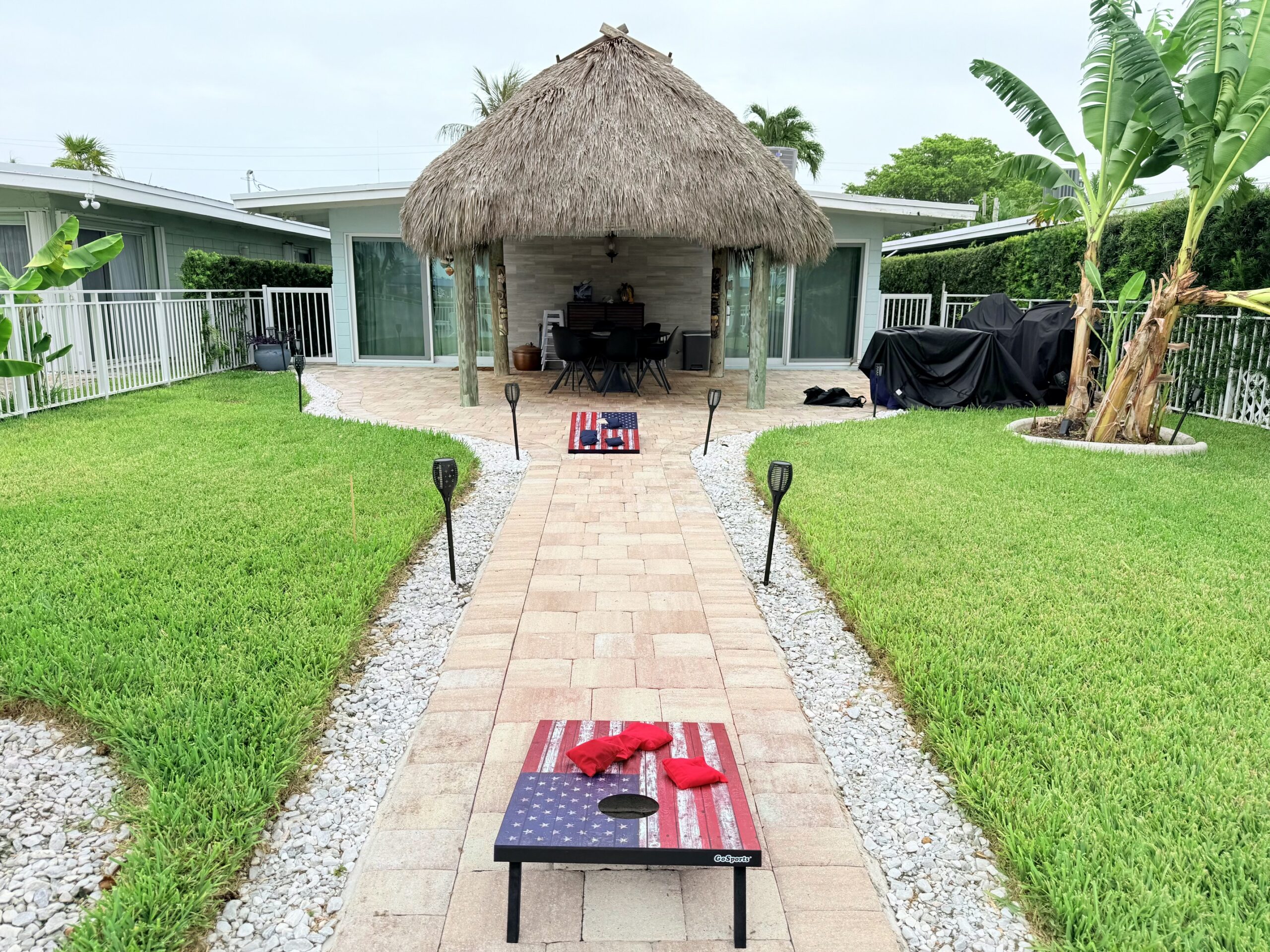 Backyard tiki hut with American flag cornhole