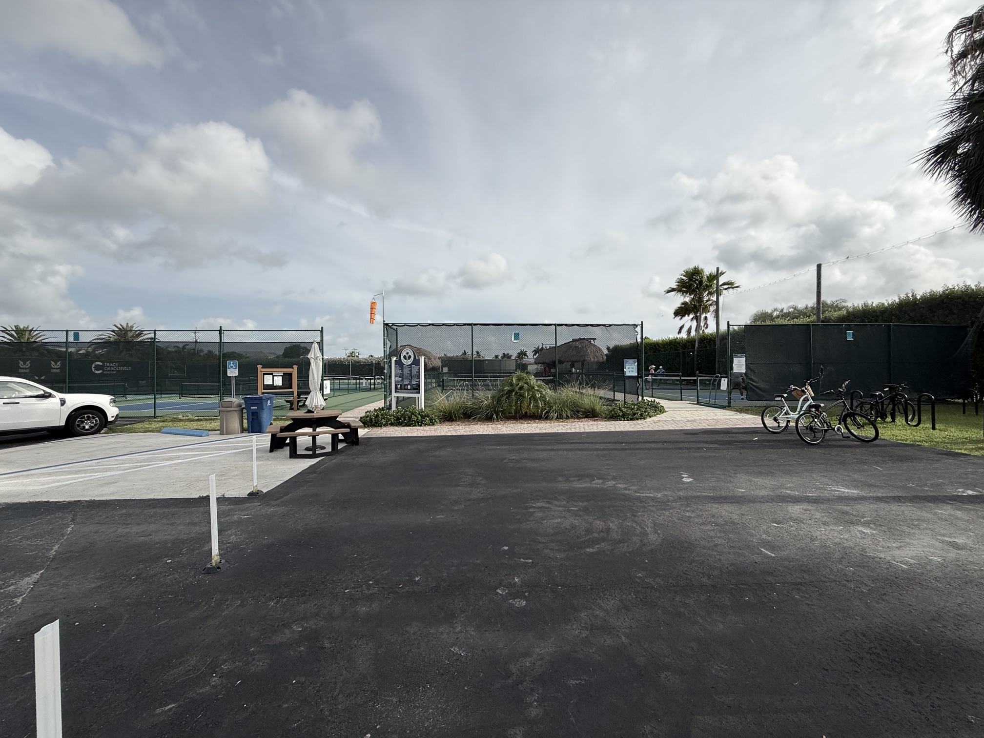 Fenced outdoor tennis courts with parked bikes