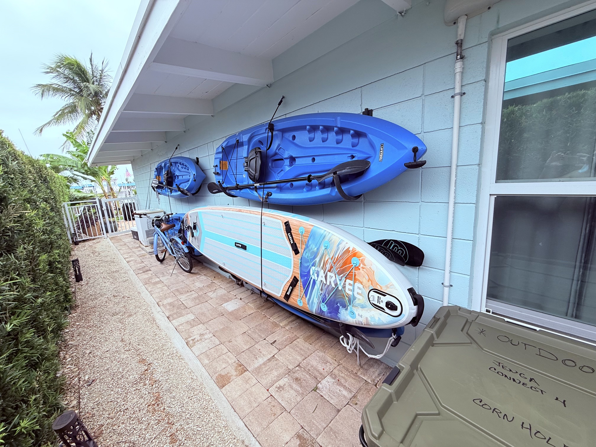 Blue kayaks and paddleboards stored outdoors